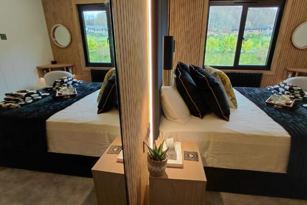 King-size bedroom with feature wall in lakeside lodge on Maes Mynan Park | YourRetreats